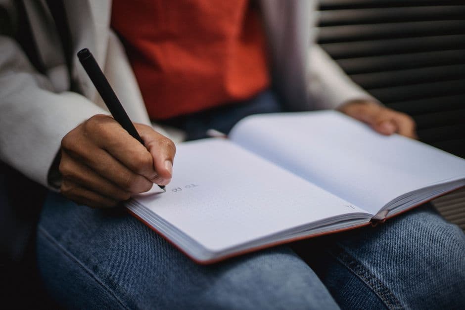Person recording daily habits in a notebook