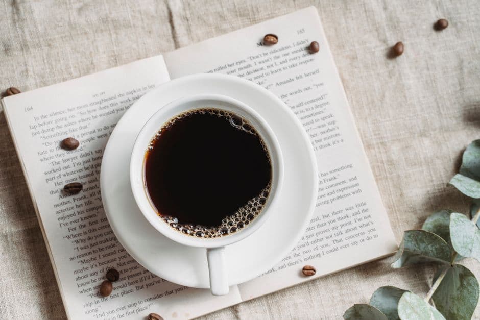 Coffee cup on an open book representing a morning habit anchor